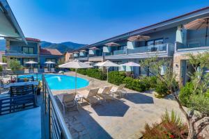 克里斯阿穆迪亚Theros Villas & Suites的享有游泳池的景色,设有椅子和遮阳伞