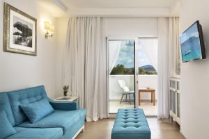坎尼吉翁Grand Hotel Cannigione的客厅设有蓝色的沙发和窗户。