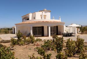 珀彻斯Relaxing Casa da Vinha carvoeiro, Algarve的前面有树木的大白色房子