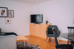 施勒肯Apartment Mohnenfluh的客厅配有电视和桌椅