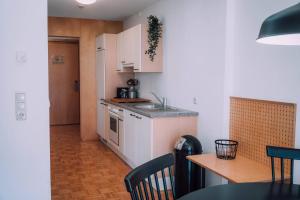 施勒肯Apartment Mohnenfluh的厨房配有白色橱柜、桌子和台面