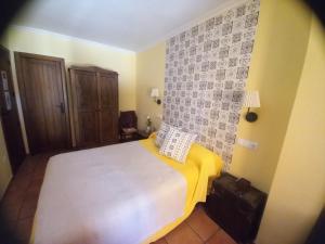 Campillo de AltobueyPosada de Campillo的卧室配有白色床和黄色毯子