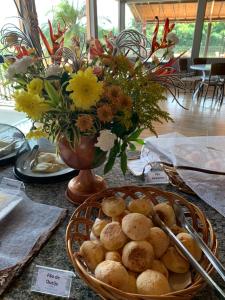 卡皮托利乌玛德米娜斯民宿的一张桌子,上面放着一篮子的食物和花瓶