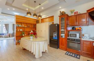 大叻Villa trung nghĩa 29的厨房配有桌子和冰箱