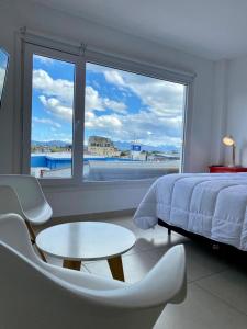 乌斯怀亚Penguins Flats 3的一间卧室配有一张床、一张桌子和一个大窗户