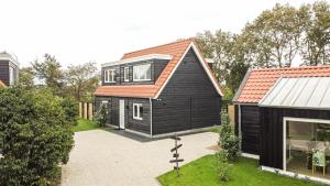 德科赫Het Mienterbos的黑色房子,有橙色屋顶