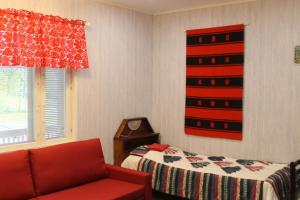 苏奥穆斯萨尔米安曼旅馆的一间卧室配有一张床和一张红色的沙发