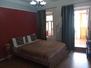 第比利斯Apartment in the heart of Old Tbilisi的一间卧室配有一张床和一个吊灯