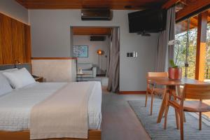 塞尔苏拉穆斯州长镇Ponta dos Ganchos Exclusive Resort的一间卧室配有一张床、一张桌子和一张桌子