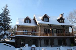 Algonquin HighlandsPine Springs Retreat with Hot Tub Steam Room Lake Kushog的大房子,在雪中设有甲板
