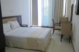 坎帕拉GNS Hotel Kampala的卧室配有床、椅子和窗户。