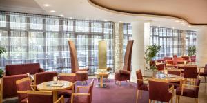 诺维格勒伊斯特拉阿米尼斯拉古娜酒店的餐厅设有桌椅和大窗户。