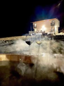 IzvoareHoliday Nature House的三个杯葡萄酒坐在热水浴缸中