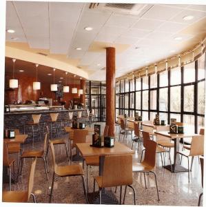 比利亚拉尔沃奥蕾莉亚之家酒店的餐厅设有桌椅和窗户。