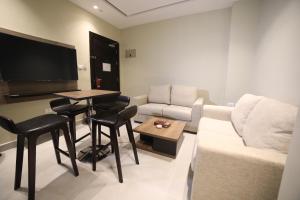 安曼فندق صحارى الخليج Sahara Gulf Hotel Apartments的客厅配有沙发和桌子