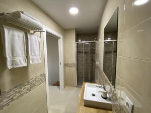 穆希亚Pousadas Mariñeiras,sl - AT "Camiño da Barca"的白色的浴室设有水槽和淋浴。