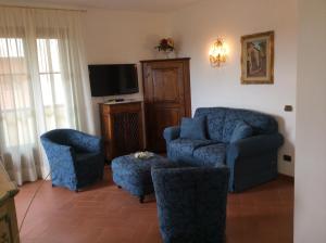 比萨伊尔波提加托旅馆的客厅配有蓝色椅子和电视