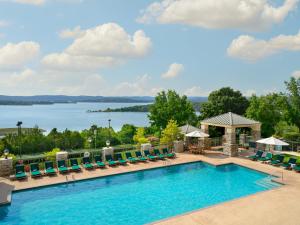 布兰森Chateau on the Lake Resort Spa and Convention Center的一个带椅子的游泳池,享有湖景