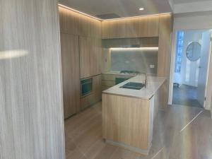 布里斯班Lovely 2 Bedroom Executive Apartment的一个带木制橱柜和水槽的厨房