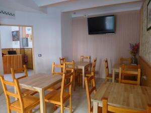 罗列特海岸切尔沃潘欣旅馆的用餐室配有木桌、椅子和平面电视