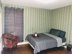 哈特福德Pacifico’s Place “2C”的一间卧室配有一张床和一把椅子