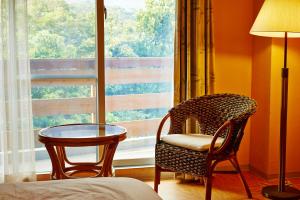 西表岛西表岛密林玛雅酒店 的一间带椅子和桌子的房间以及窗户