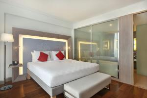 马六甲Noble Resort Hotel Melaka的卧室配有带红色枕头的大型白色床