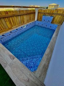 Al RuwisAl Asala Resort的一座蓝色瓷砖的大型游泳池