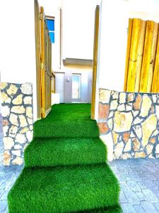 Al RuwisAl Asala Resort的一条有绿草和石墙的楼梯