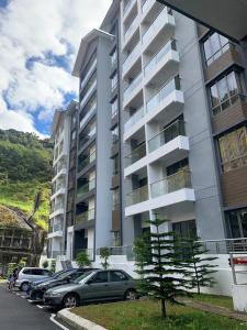 金马仑高原Palas Horizon, 4 Bedroom Apartment的一座大型公寓楼,前面设有停车场