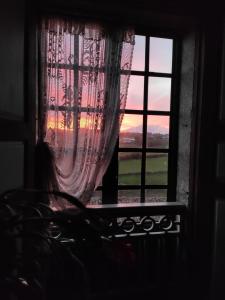 卢戈Casa do Pacio Sabadelle的一位女人从窗户望着日落