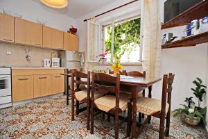 科尔丘拉Green Garden House的厨房配有桌椅和窗户。