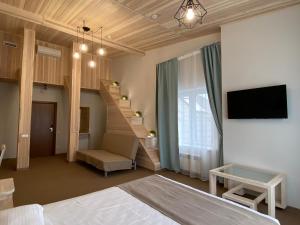 喀山Irbis Hotel的一间卧室设有一张床,楼梯配有电视。