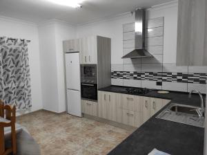 玛泽甘Apartamento para familias的厨房配有水槽和炉灶 顶部烤箱