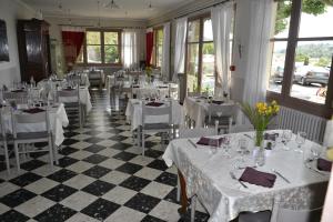 Rians海滨大道好客酒店的餐厅设有白色的桌椅和窗户。