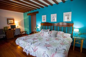 UclésHotel Casa Palacio Uclés的一间卧室设有一张床和蓝色的墙壁