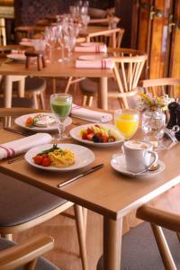里斯本São Vicente Alfama Hotel by TRIUS Hotels的一张木桌,上面放着食物和饮料