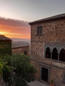 巴尼奥雷焦Il Vento e la Ginestra的享有砖砌建筑的日落美景,背景为日落