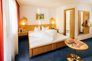 皮茨河谷圣莱昂哈德维泽酒店的酒店客房配有一张床铺和一张桌子。