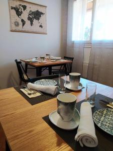卡尔卡松RIBA D'AUDE的一张木桌,上面有盘子和杯子
