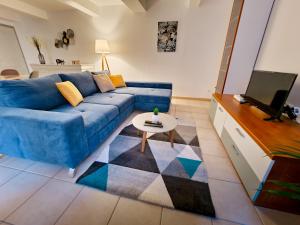 CarvinFabrice et Frédérique的客厅配有蓝色的沙发和电视
