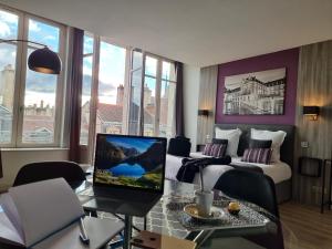 第戎城市阁楼公寓酒店的酒店客房配有一张床、一张书桌和一台笔记本电脑