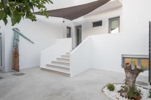 纳乌萨Rivière Residence Paros的白色的房子,有楼梯和树