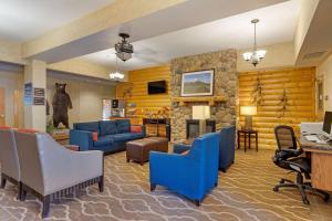 安克雷奇安克雷奇国际机场康福特套房酒店的客厅配有蓝色椅子和壁炉