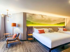 伊图Novotel Itu Terras de São José Golf & Resort的酒店客房设有两张床,墙上挂有绘画作品