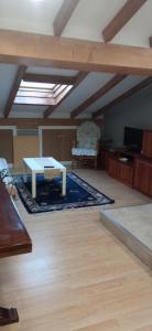 拉瓜迪亚ático的客厅配有桌子和地毯。