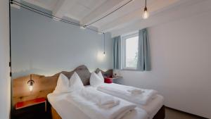 巴德伊舍Bett & Berg Bad Ischl, Self Check-In的一间卧室配有带白色床单和枕头的床。