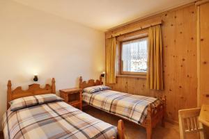 利维尼奥Baita sulle Alpi的一间卧室设有两张床和窗户。