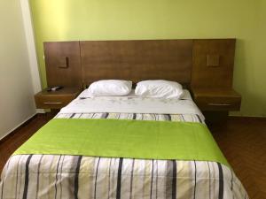 圣塔芭芭拉-山美纳Figaro Hotel Samana的一间卧室配有一张带2个床头柜的大床
