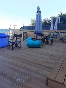 金沙卡巴科姆海滨度假屋的甲板上的一组椅子和一把遮阳伞